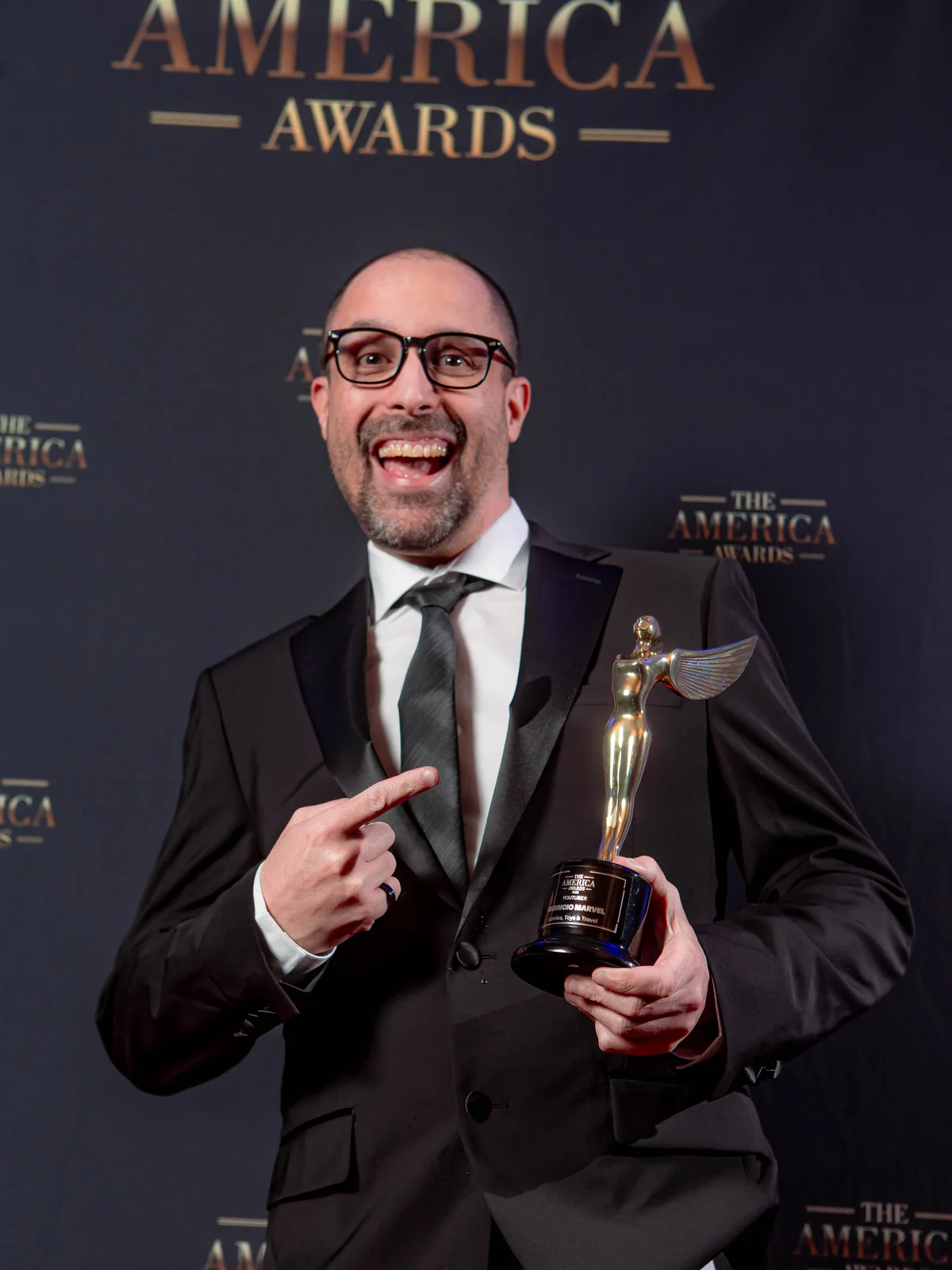 Honoree holding the official America Awards trophy during the award presentation