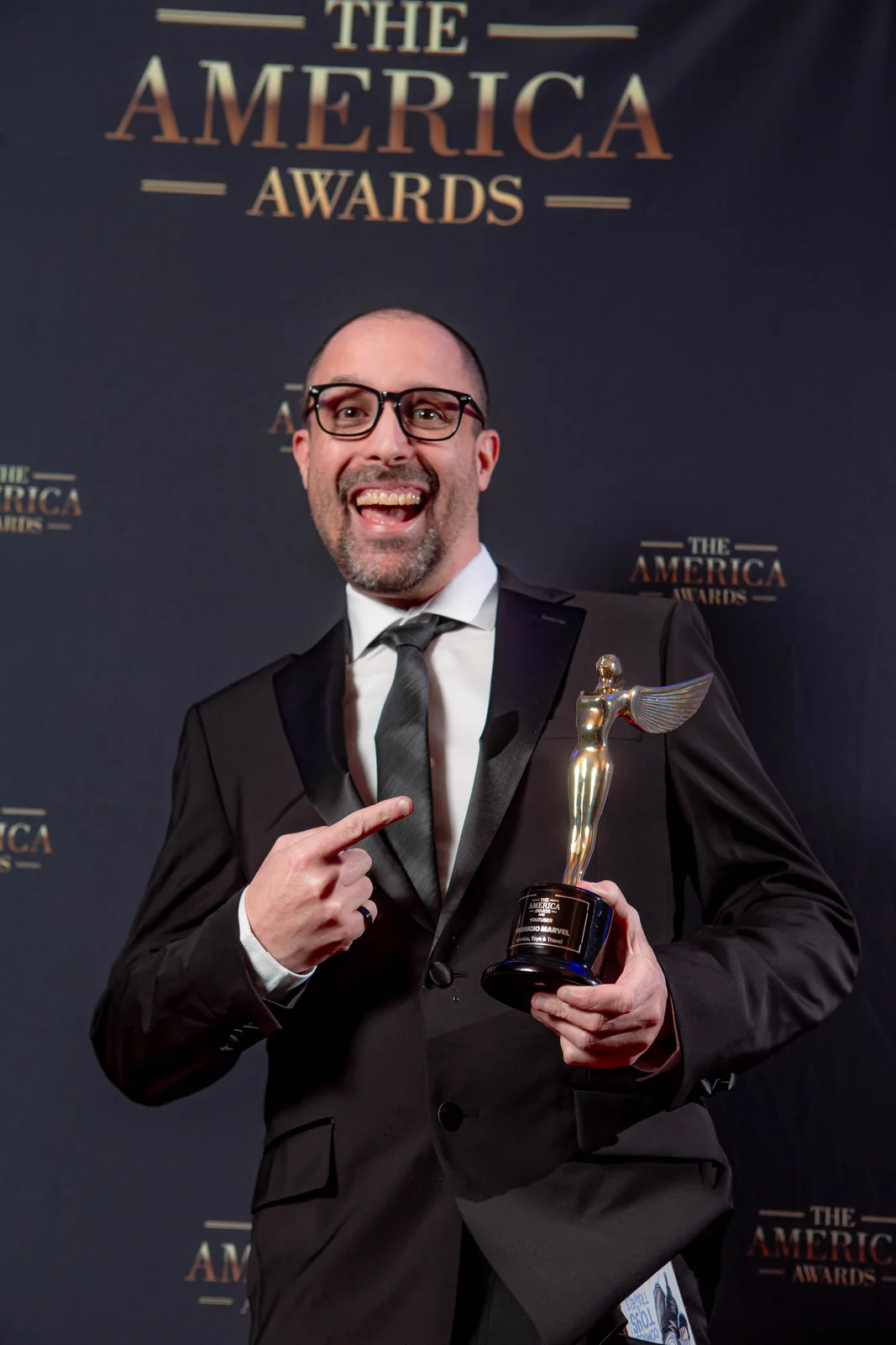 Honoree holding the official America Awards trophy at the ceremony