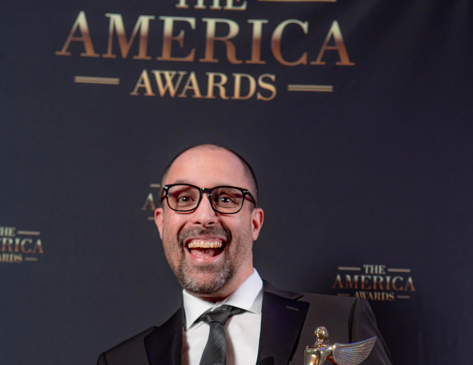 Honoree celebrating with The America Awards trophy